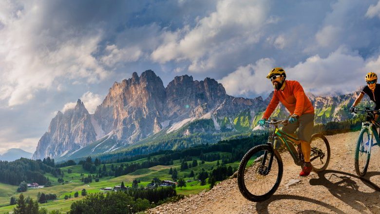 Un cycliste sur une route de montagne, entre falaises et pinèdes.
