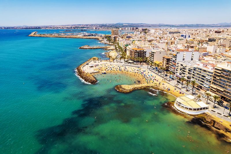 Vue aérienne du front de mer de Torrevieja, ses criques turquoise et son port au fond