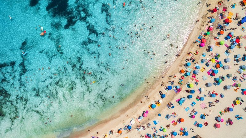 Une plage de la Costa Blanca vue du ciel, parasols alignés sur le sable.